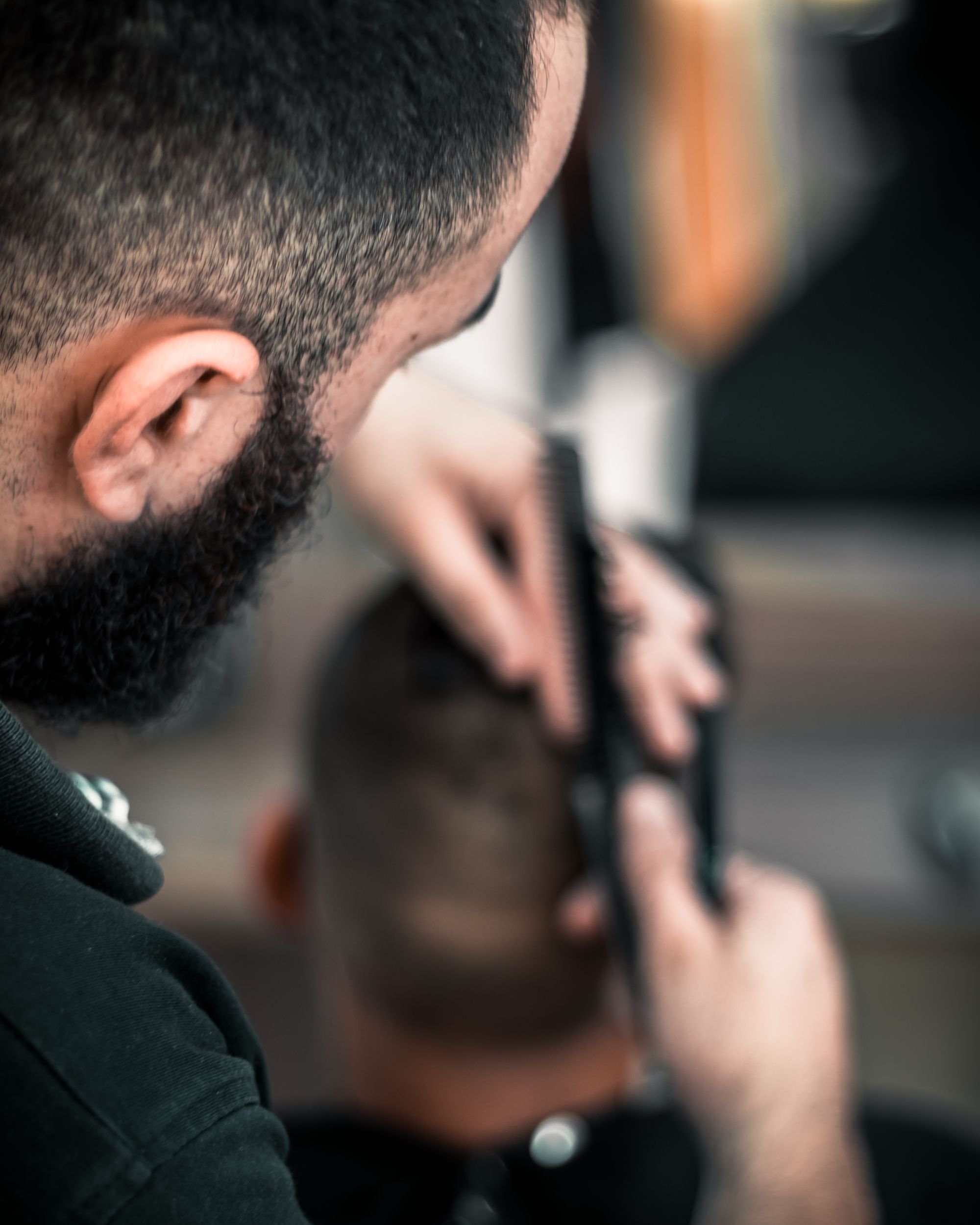 Detalle editorial de un corte de cabello para hombre con tijeras.